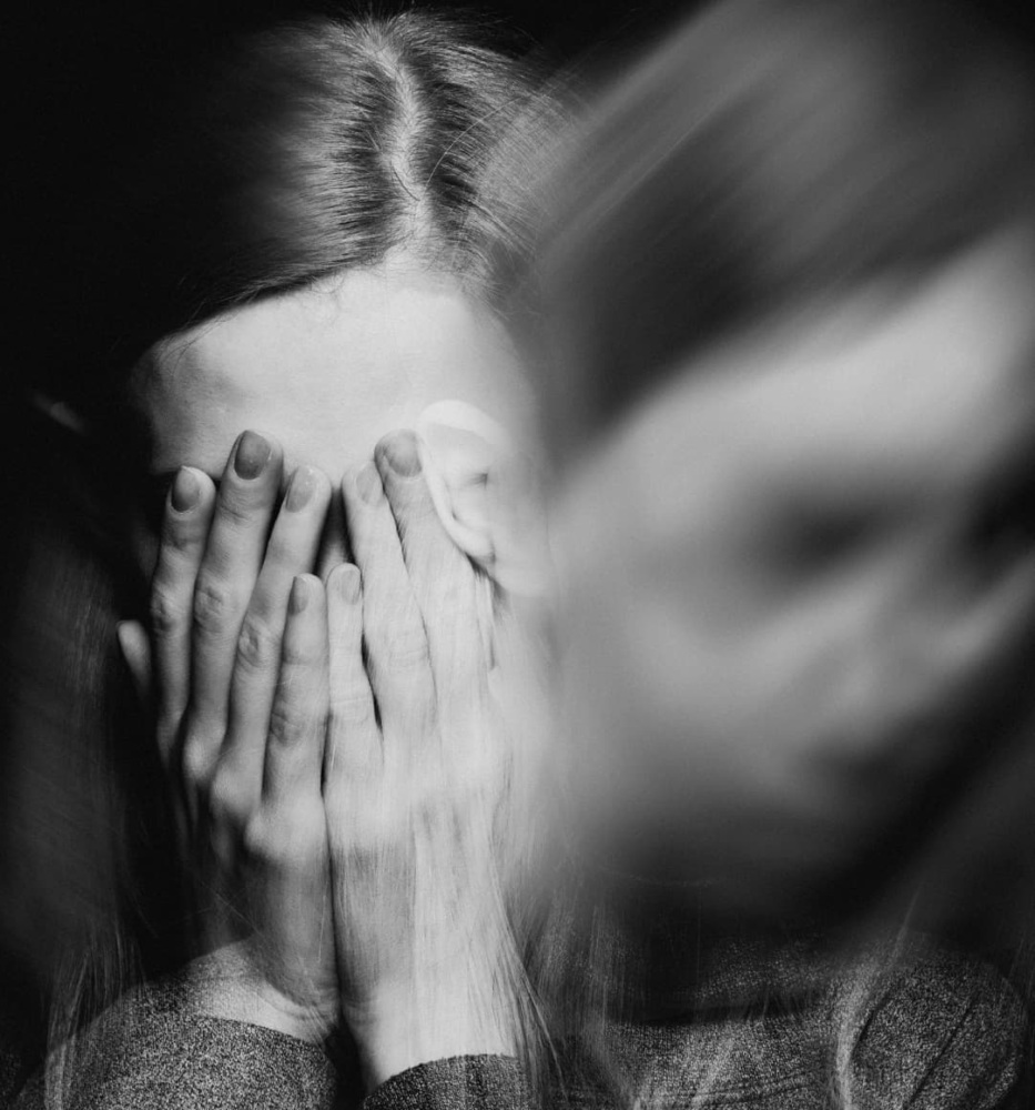 black and white distorted photo of a woman covering her eyes